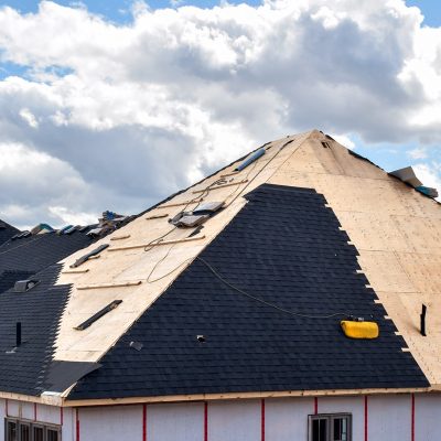 The process of installation of black roof shingles on new residential home
